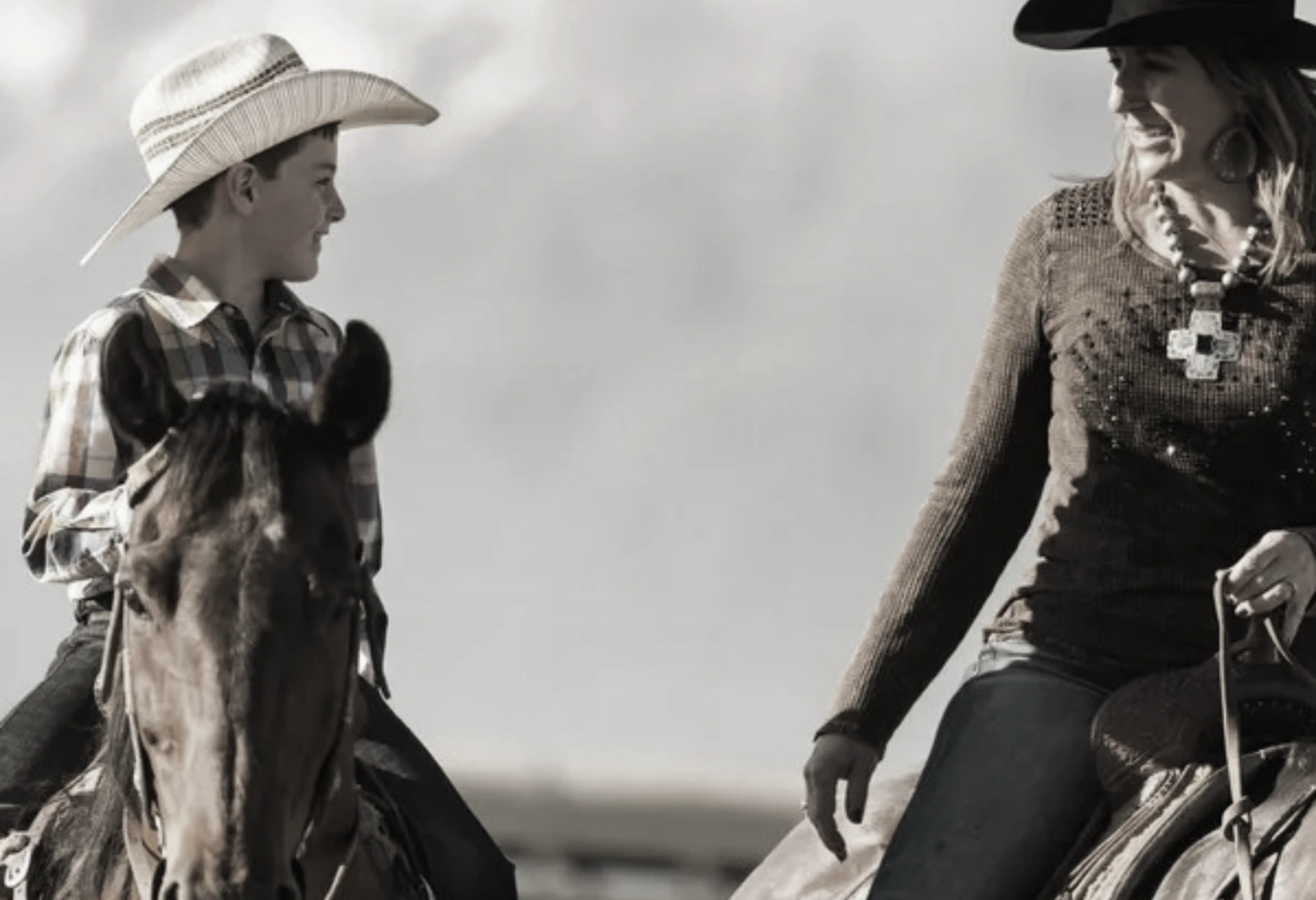 Young rider sharing a smile with a mentor on horseback